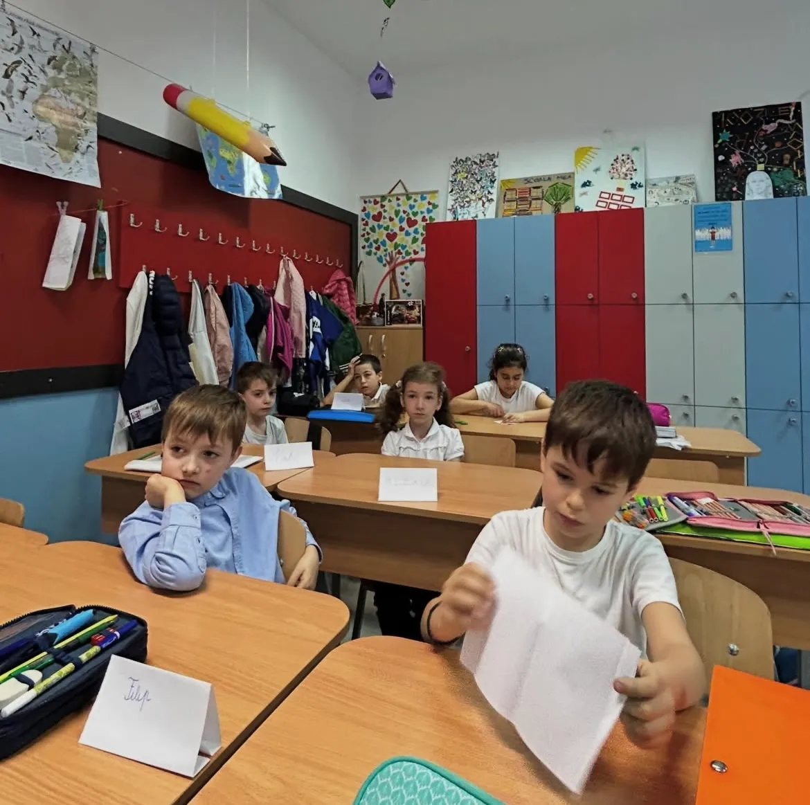 Copii într-o sală de clasă, în timpul unui atelier despre emoții susținut de Flaviu la școală